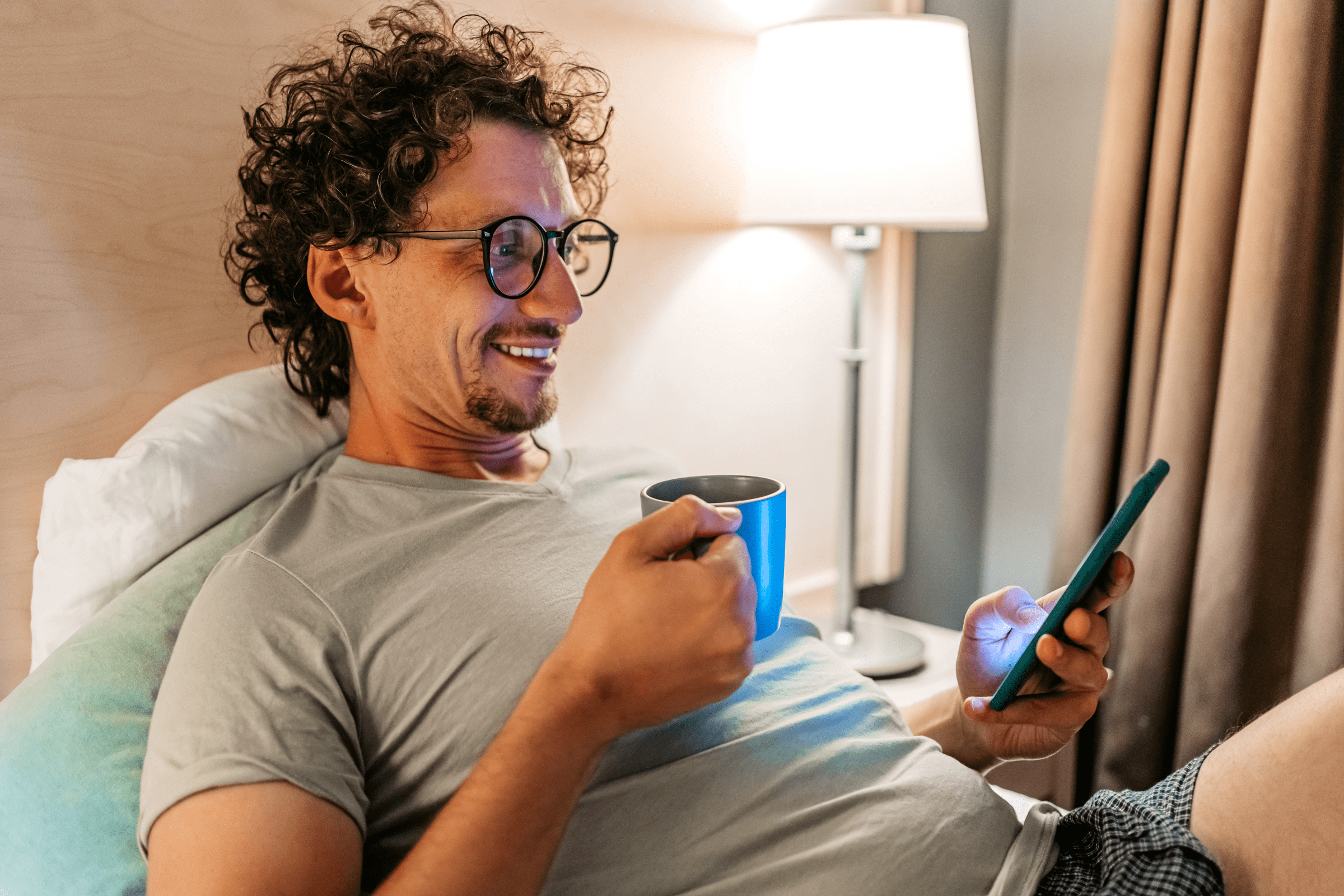 Mann sit avslappa i ein kvardagssituasjon og ser på mobilen.