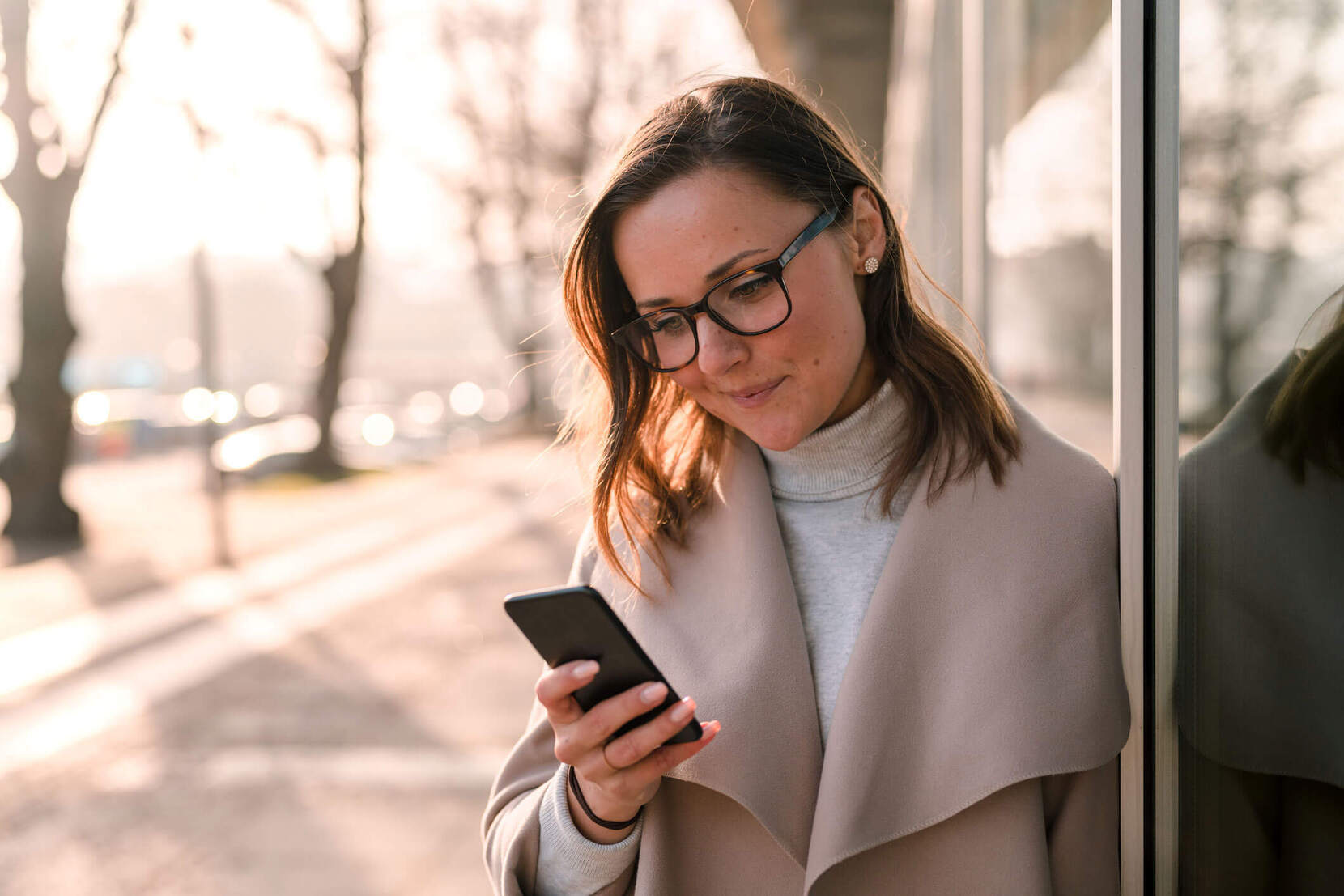 Kvinne som er ute og ser på mobilen