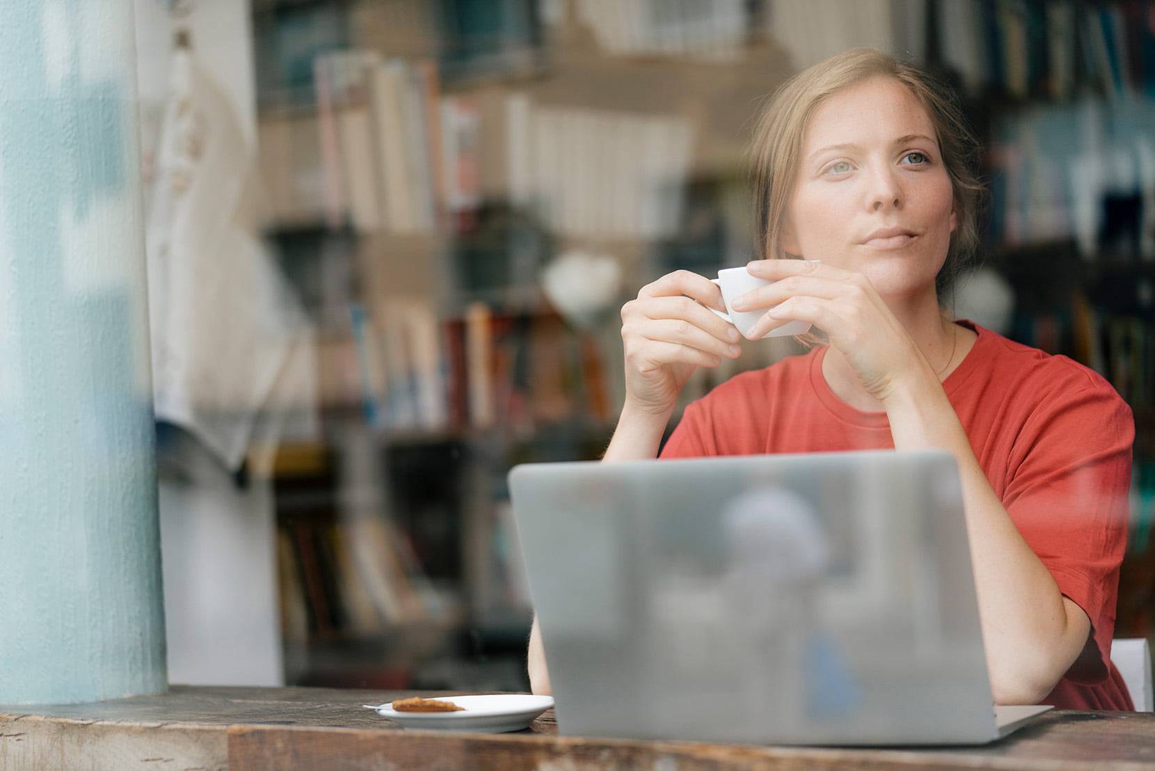 Ung dame med kaffekopp og PC på kafe