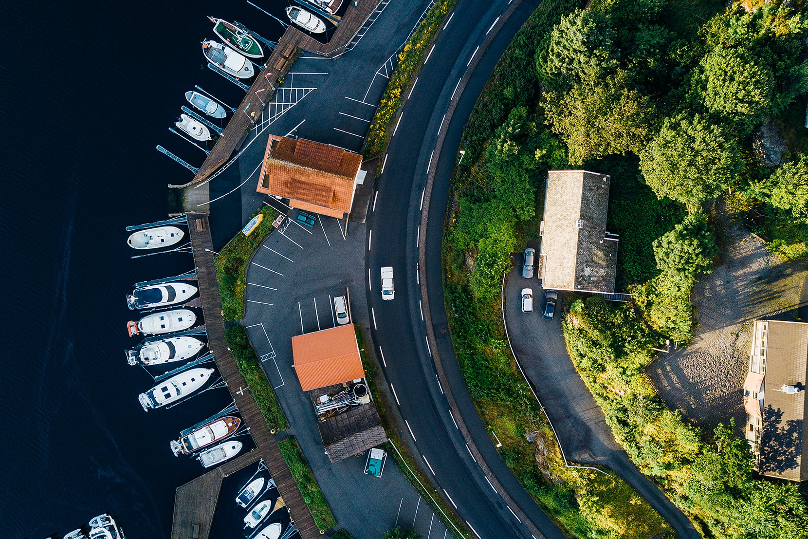 Dronebilde av bebyggelse og vei langs sjøen i Kopervik på Karmøy