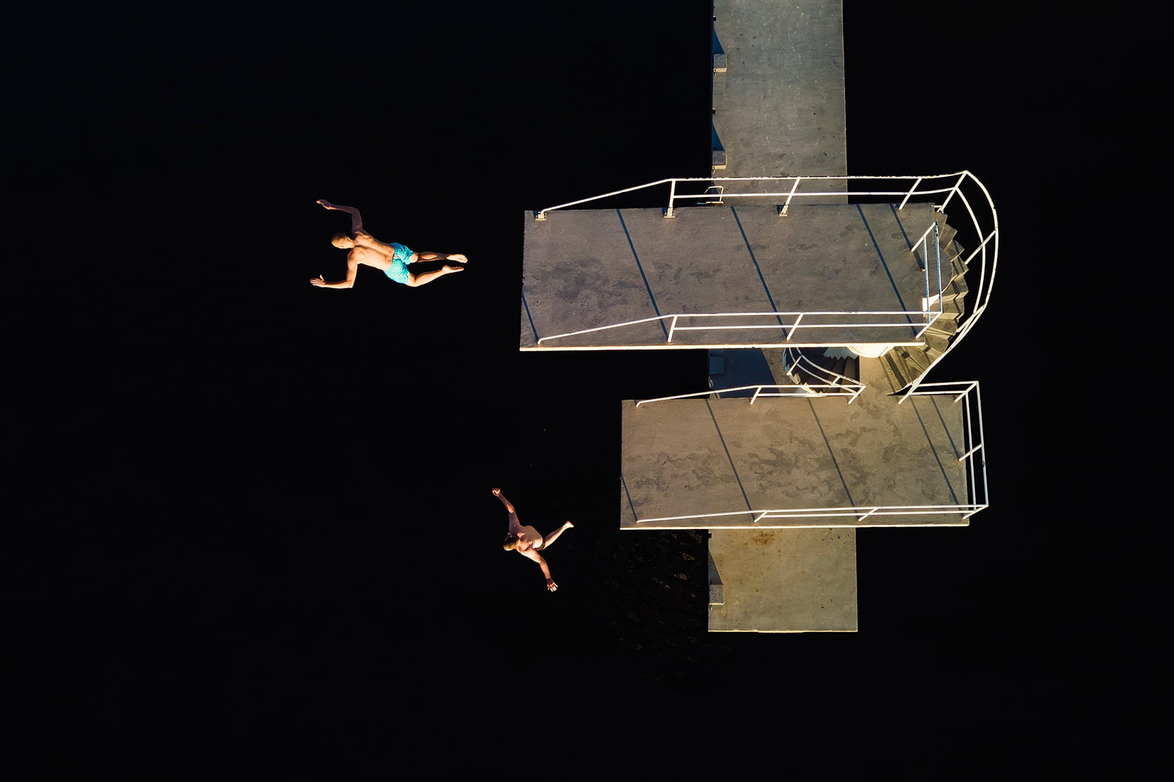 Dronebilde av to mennesker som hopper fra stupetårnet i Vangen i Haugesund