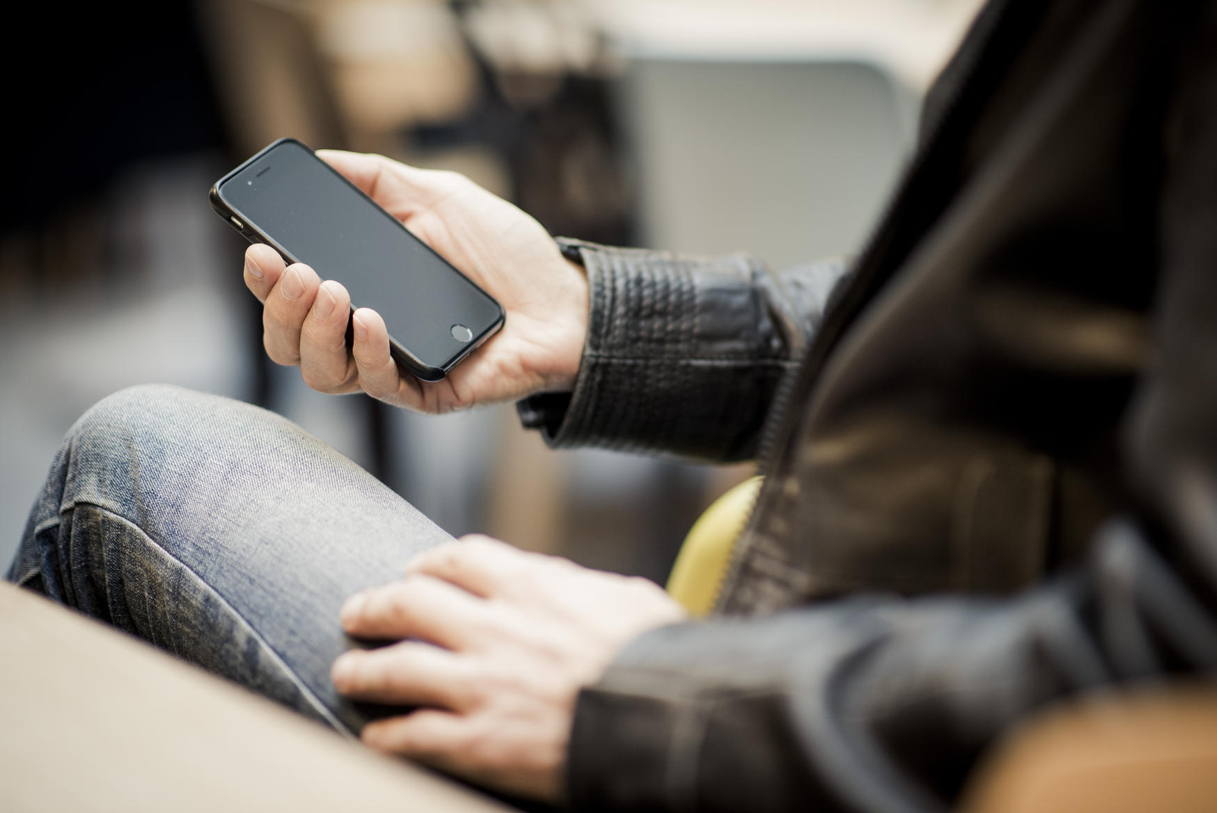 Hånd holder mobil. foto